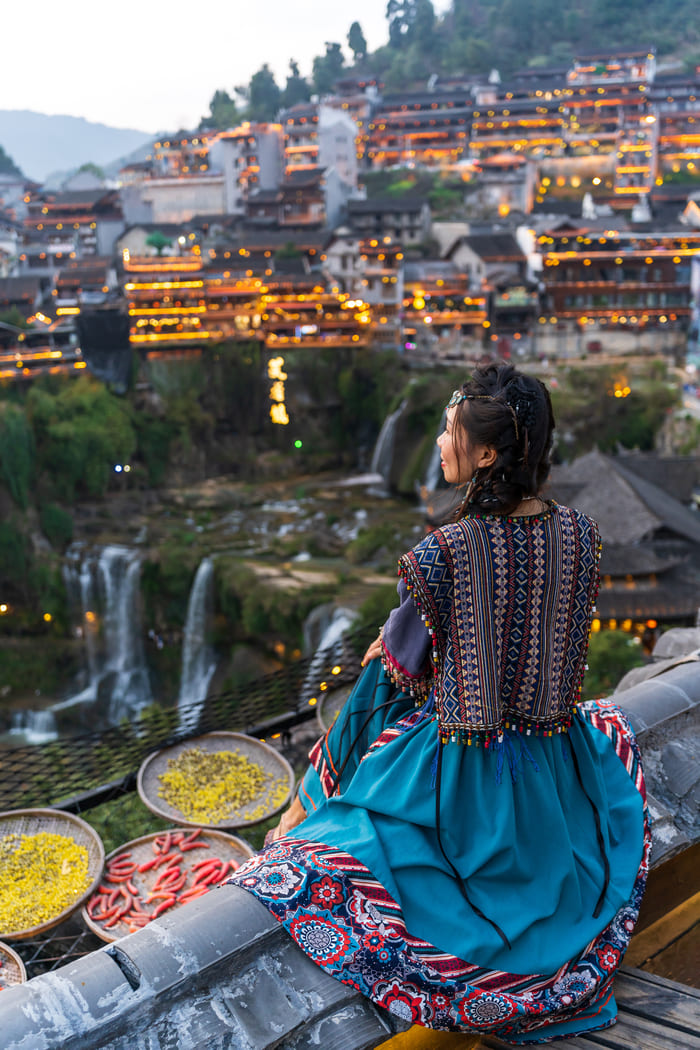 Mujer viendo paisaje en la ciudad Lijiang